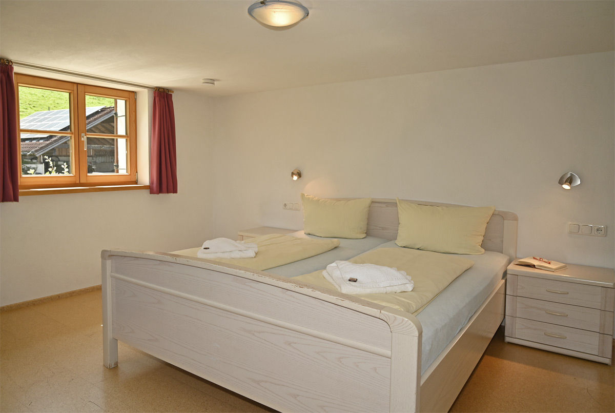 Schlafzimmer mit Doppelbett und Bergblick