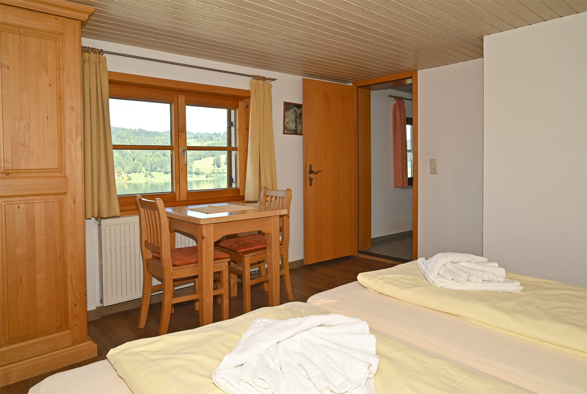 Schlafzimmer mit Sitzgruppe und Blick auf den See